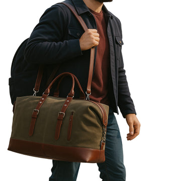 About Us Timeless Travel Carry bag in durable green canvas with genuine brown leather accents structured silhouette dual top handles and reinforced base held by model showcasing luxury styling upscale craftsmanship premium finish and versatile travel functionality
