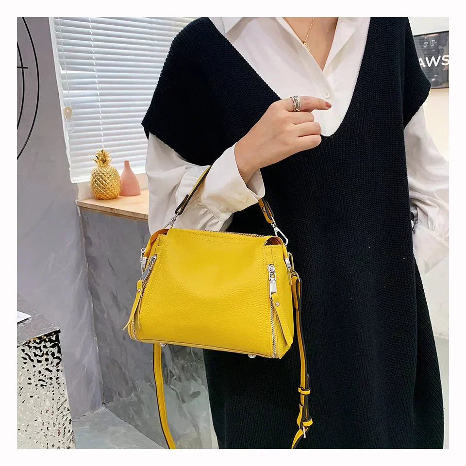 Timeless Zip Carry bag in vibrant yellow premium genuine leather with upscale silver hardware worn crossbody in lifestyle setting showcasing bold elegance and upscale everyday utility