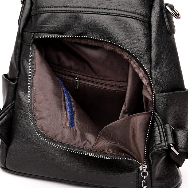 Urban Ease Backpack women’s black vegan leather crossbody backpack bag with silver hardware showing zippered brown interior compartments