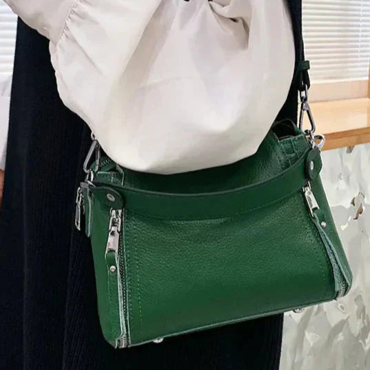 Timeless Zip Carry in green premium genuine leather with upscale silver hardware worn crossbody displayed in lifestyle setting showcasing elegant everyday utility and upscale styling