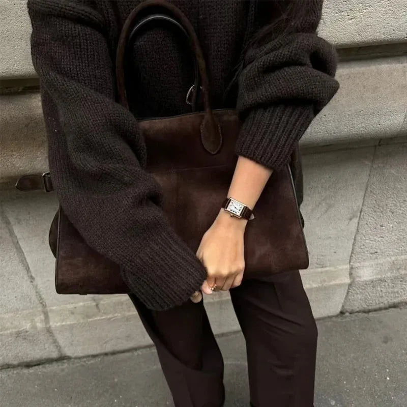 model holding modern grace tote a brown leather handbag