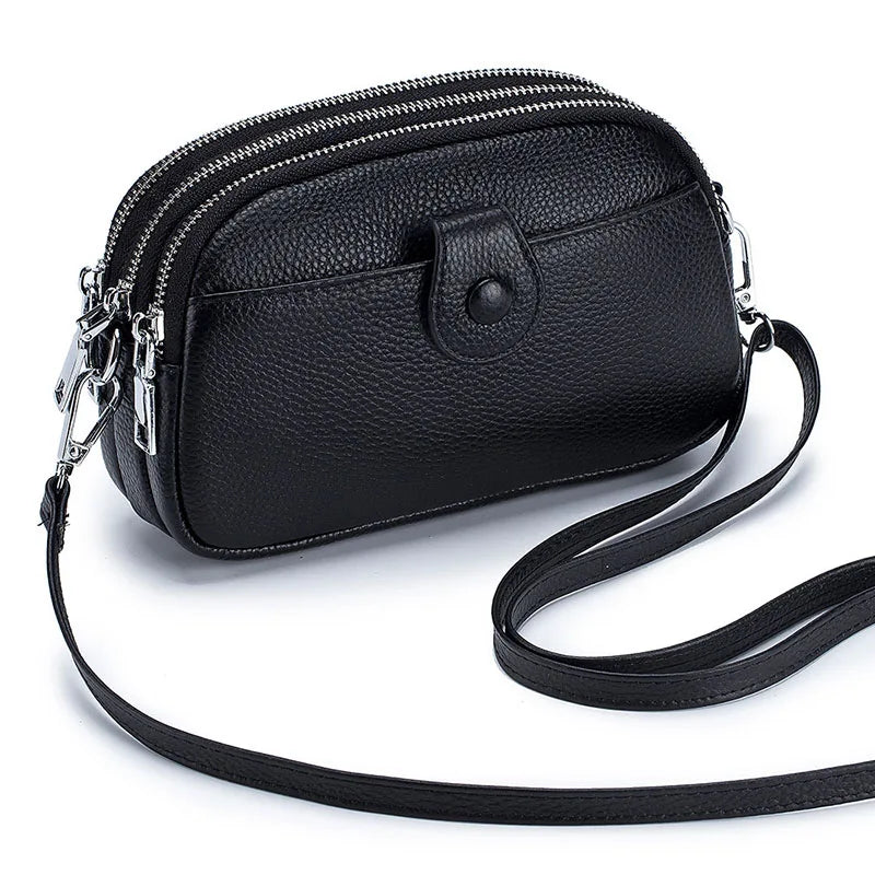 Signature Convertible Carry women’s black pebbled genuine leather crossbody bag with zip closure, front snap pocket and long strap with silver hardware