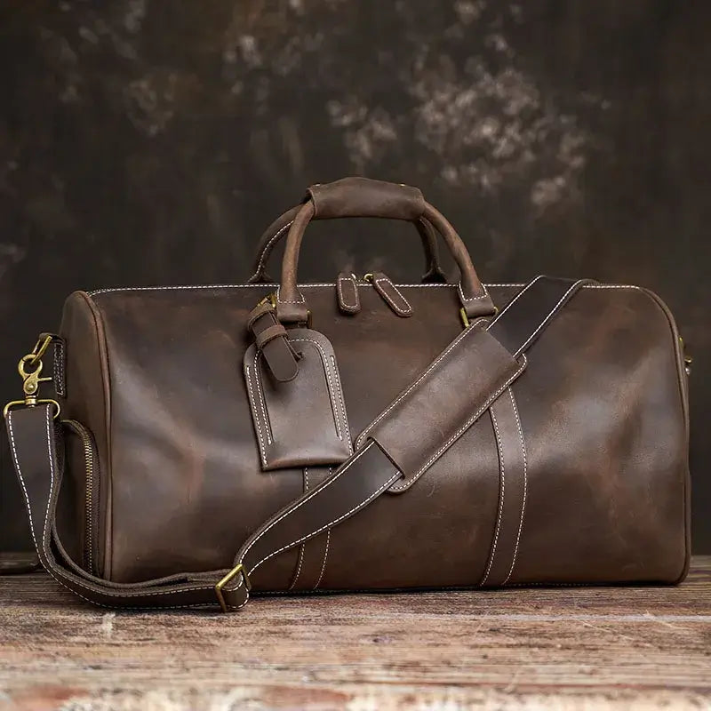 Heritage Leather Weekender in brown coffee full grain luxury genuine leather with structured duffel silhouette dual top handles detachable shoulder strap and matching luggage tag showcasing heritage premium craftsmanship rich patina upscale detailing and timeless travel aesthetic