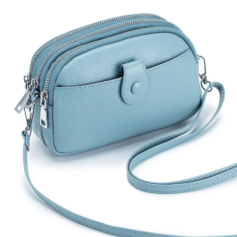 Signature Convertible Carry women's genuine leather crossbody bag in light blue with 3 zip pockets, front snap pocket, adjustable strap with silver hardware