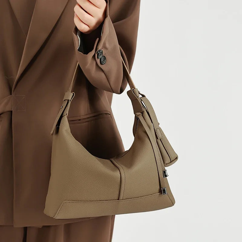 Metro Leather Hobo women's genuine leather shoulder bag with coin pouch in taupe held by model in brown suit