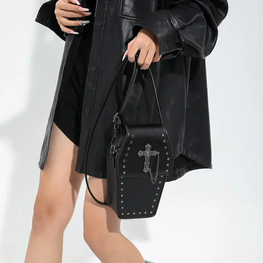 Midnight Edge Crossbody bag in luxury black vegan leather with silver cross embellishment and metal stud accents shown held by model  showcasing bold gothic design durable premium construction and upscale edgy everyday styling