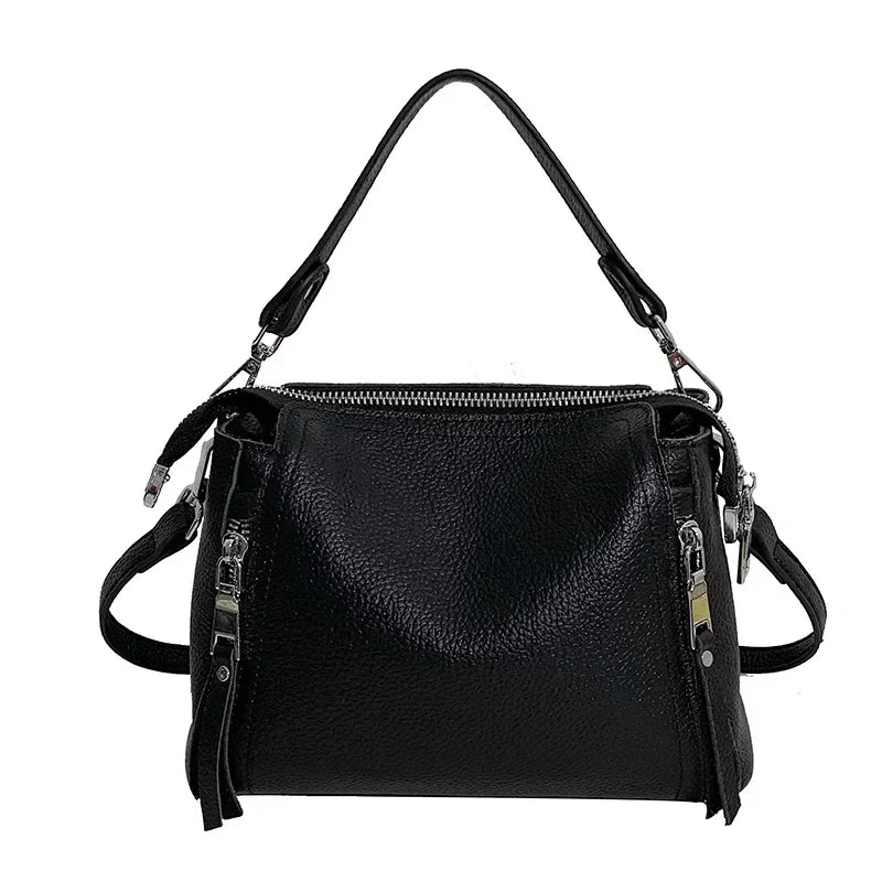 Timeless Zip Carry bag in black premium genuine leather with upscale silver hardware softly structured silhouette with top zipper closure removable top handle and removable and adjustable shoulder strap showcasing refined utility and elevated everyday style