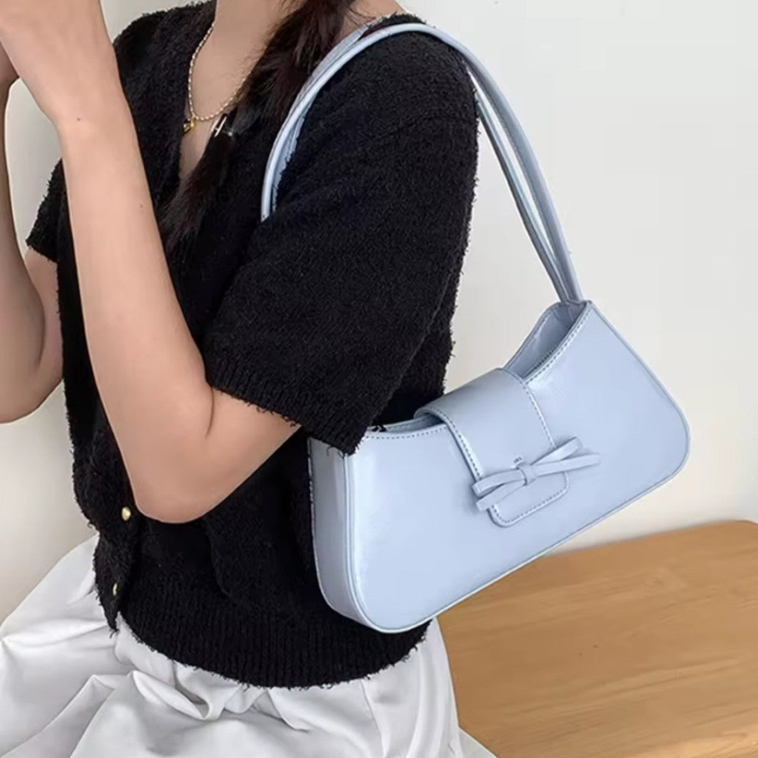 Timeless Bow Carry blue luxury vegan leather bag worn over shoulder upscale lifestyle fashion look
