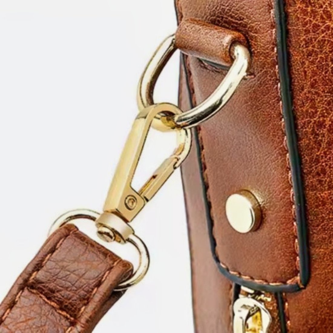 Classic Carry Hobo in brown premium vegan leather showing elegant gold tone carry hook attached to stitched strap with riveted d ring showcasing upscale hardware secure strap attachment and refined luxury craftsmanship
