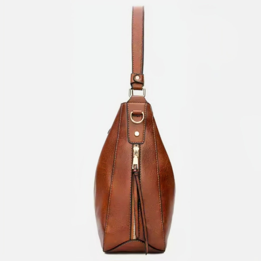 Classic Carry Hobo side view in brown premium vegan leather with relaxed elegant crescent silhouette vertical side zipper strap with metal ring attachment and structured base showcasing soft texture upscale detailing and versatile luxury everyday styling