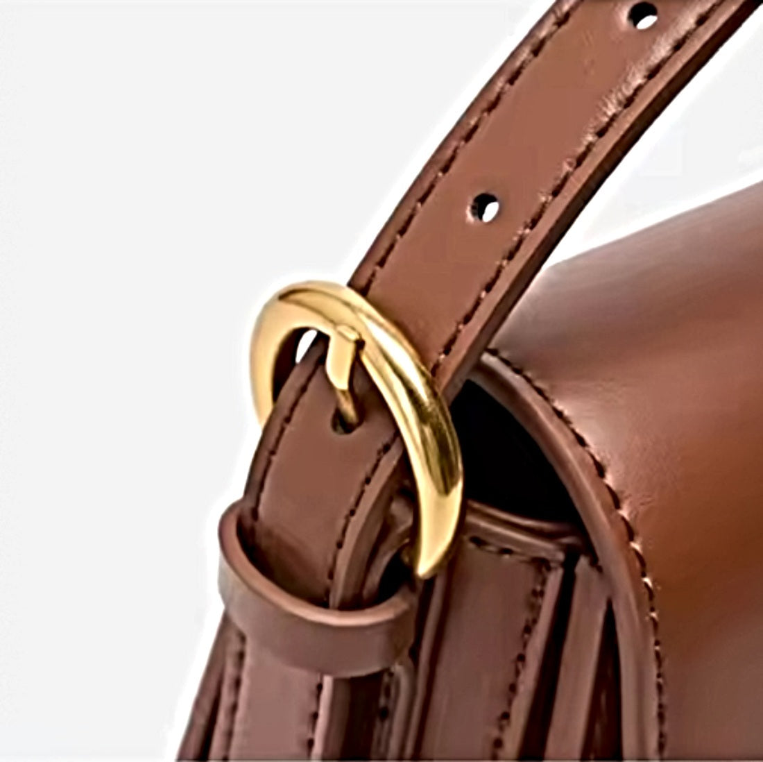 Timeless Charm Satchel close up of caramel genuine kitt cross grain leather strap with stitched edges gold d ring buckle and multiple adjustment holes attached to matching satchel showcasing luxury detailing upscale craftsmanship and premium adjustable functionality