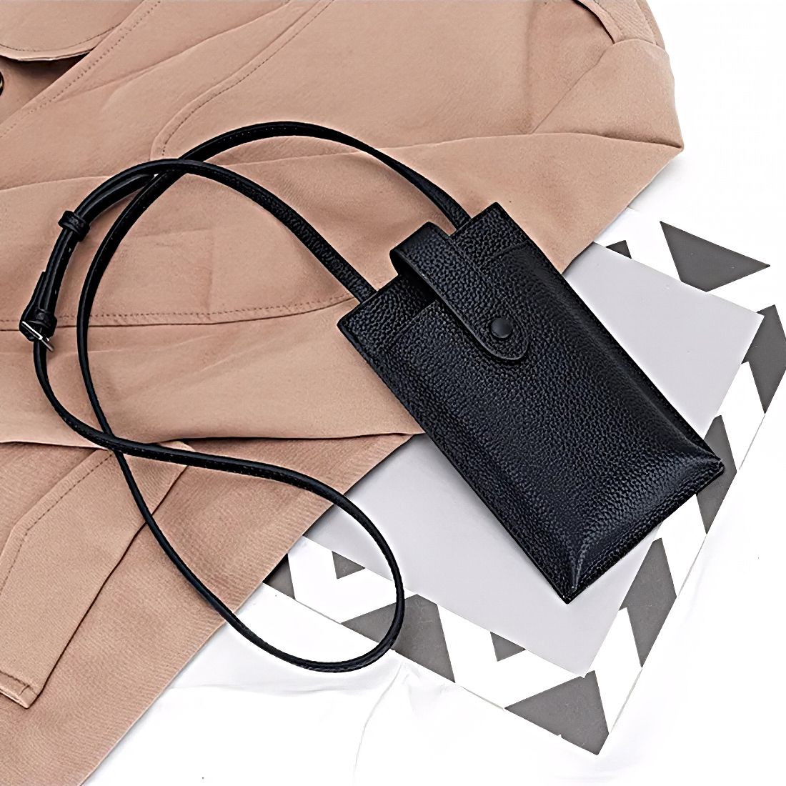 Black womens genuine leather phone crossbody bag City Snap Carry compact leather wallet crossbody small tote bag with adjustable strap shown with trench coat