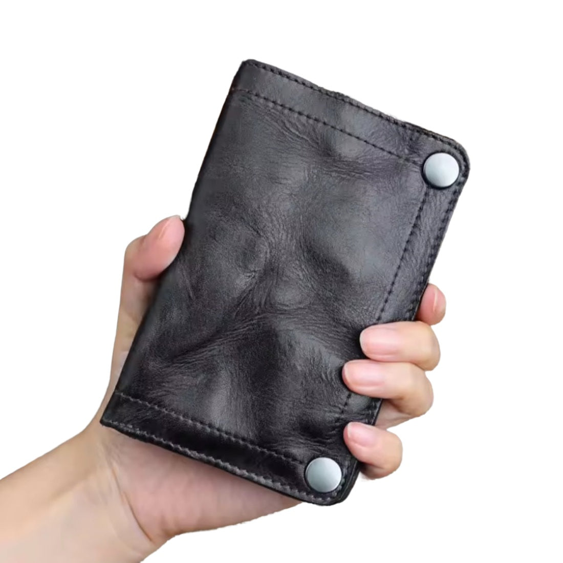 Hand holding Creased Heritage Fold black luxury vintage genuine leather wallet showing size and highlighting craftsman features