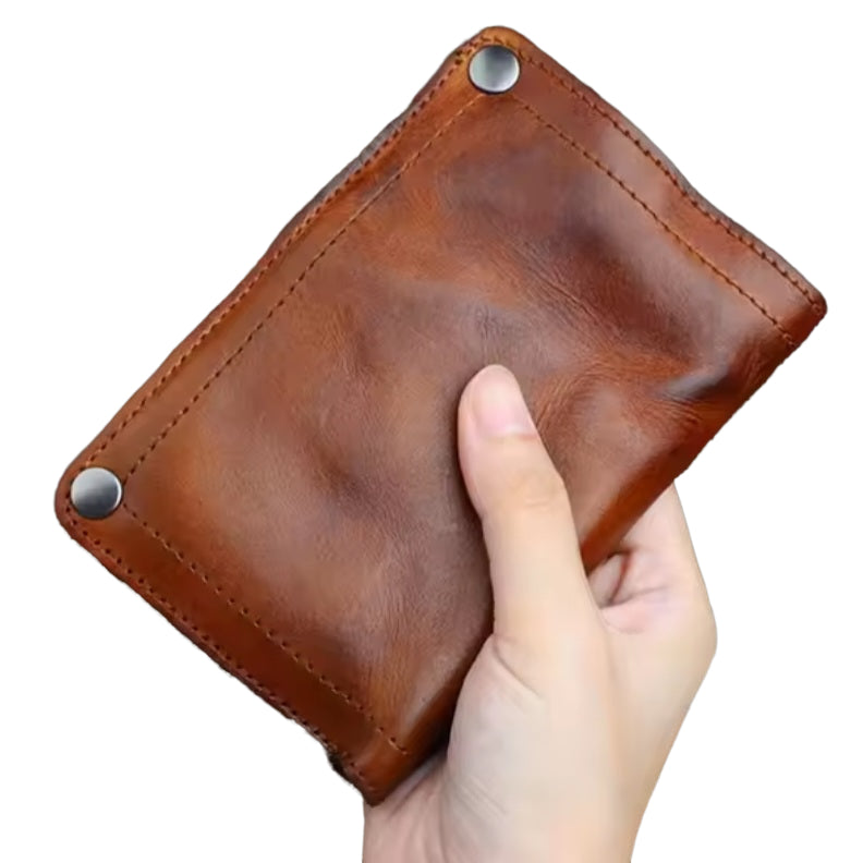 Hand holding Creased Heritage Fold brown luxury vintage genuine leather wallet showing compact size and vintage patina