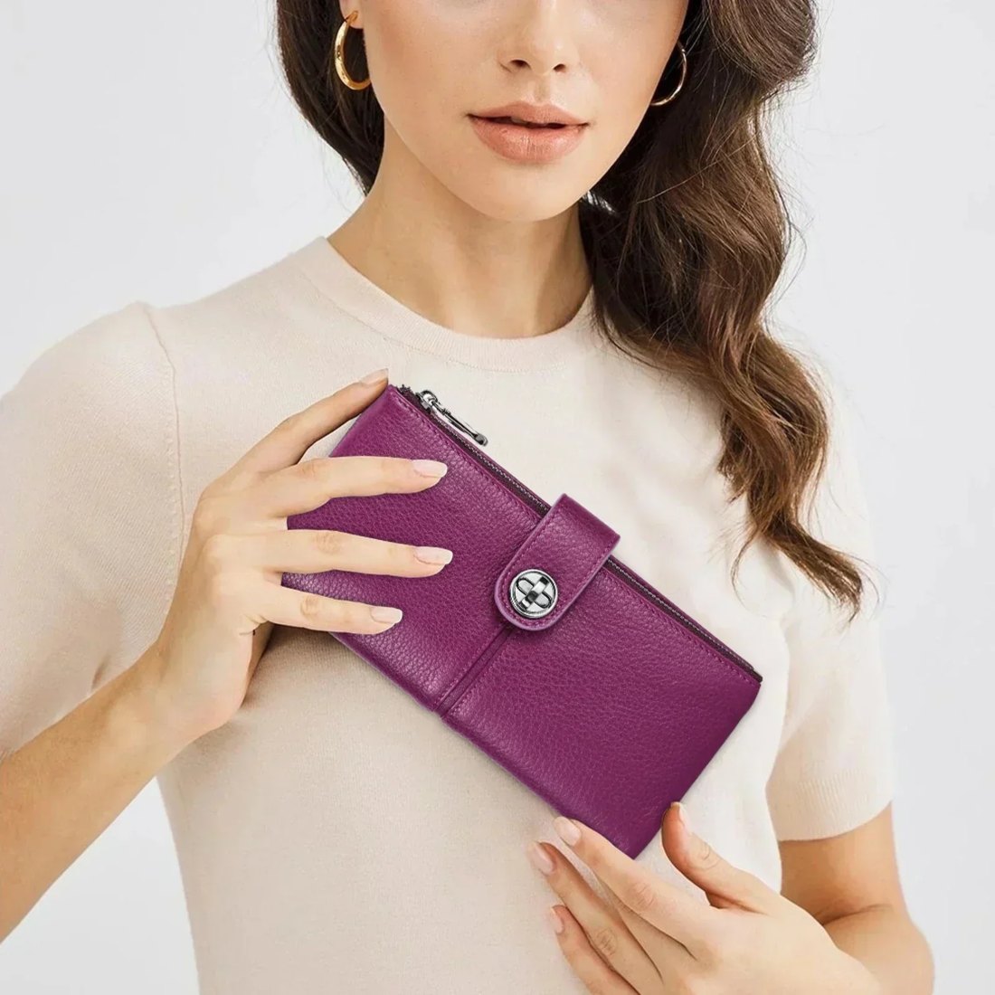 Essential Carry Clutch with RFID and AirTag slot worn in purple luxury leather as a premium fashion accessory