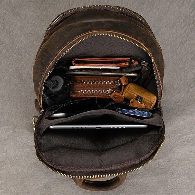 Frontier Leather Sling men's crossbody bag open, showing brown crazy horse leather material and organized interior compartments with personal items.