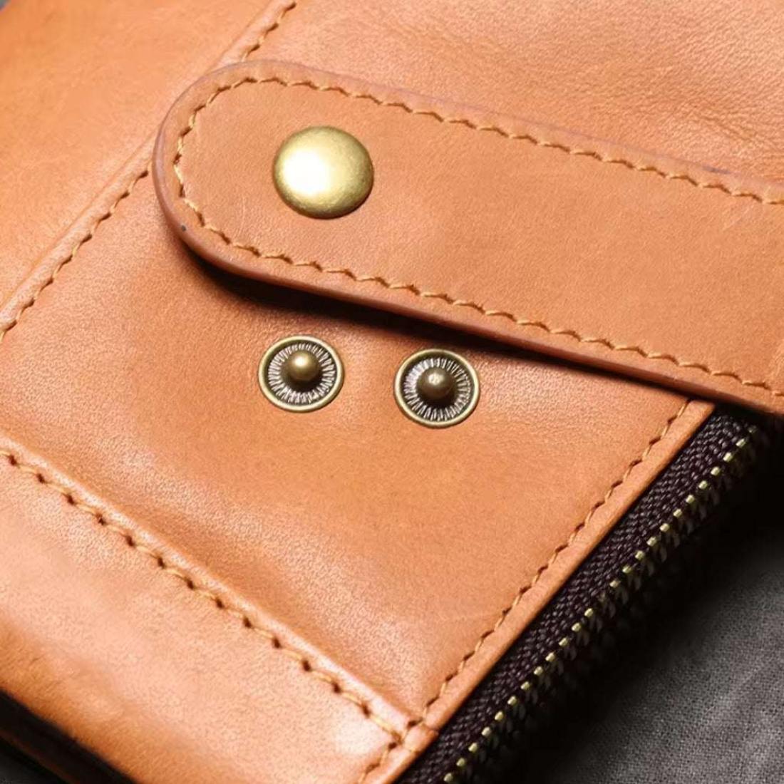 Heritage Fold luxury wallet in brown retro oil wax genuine leather showing corner section with premium gold zipper flap with snap button and two metal rivets visible stitching and smooth texture showcasing upscale detailing secure closure and durable everyday durable design