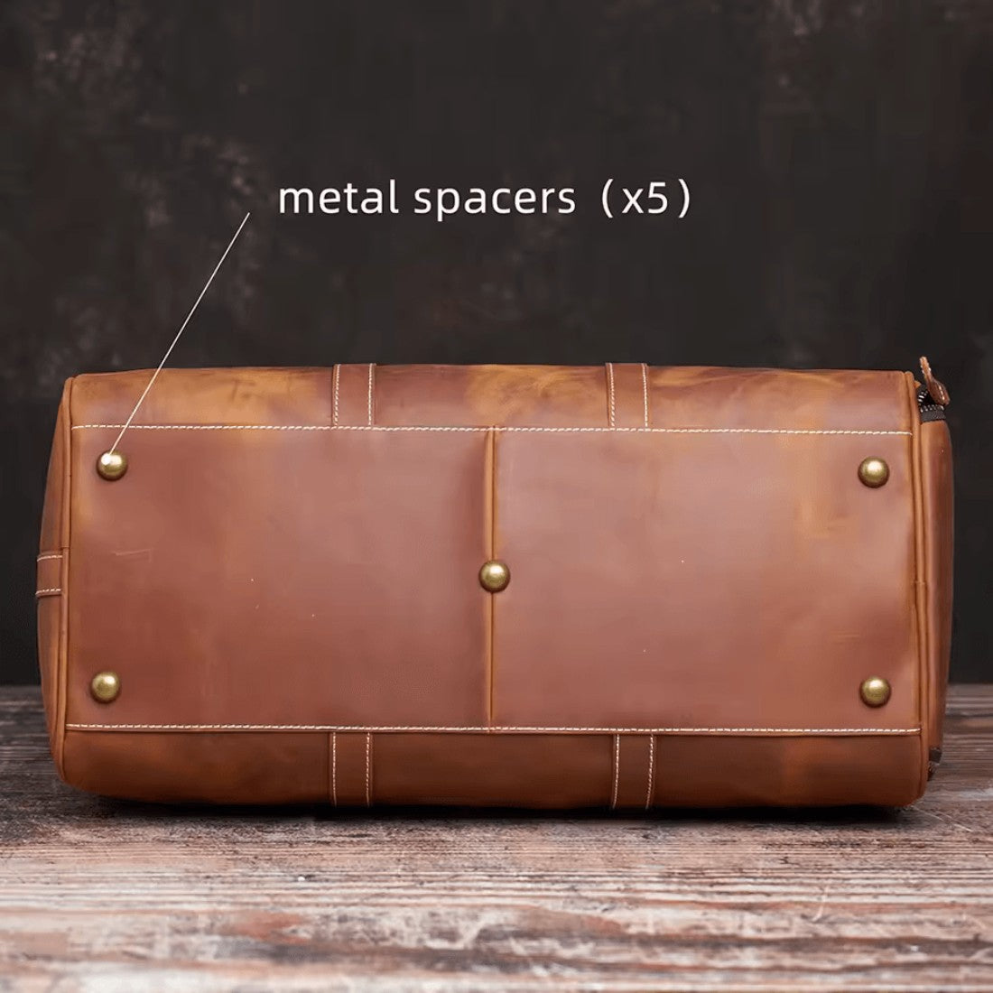 Heritage Leather Weekender in luxury brown thick vintage genuine leather with cylindrical silhouette shown from bottom angle featuring five metal spacers for reinforced support showcasing classic craftsmanship upscale detailing and durable premium travel ready construction
