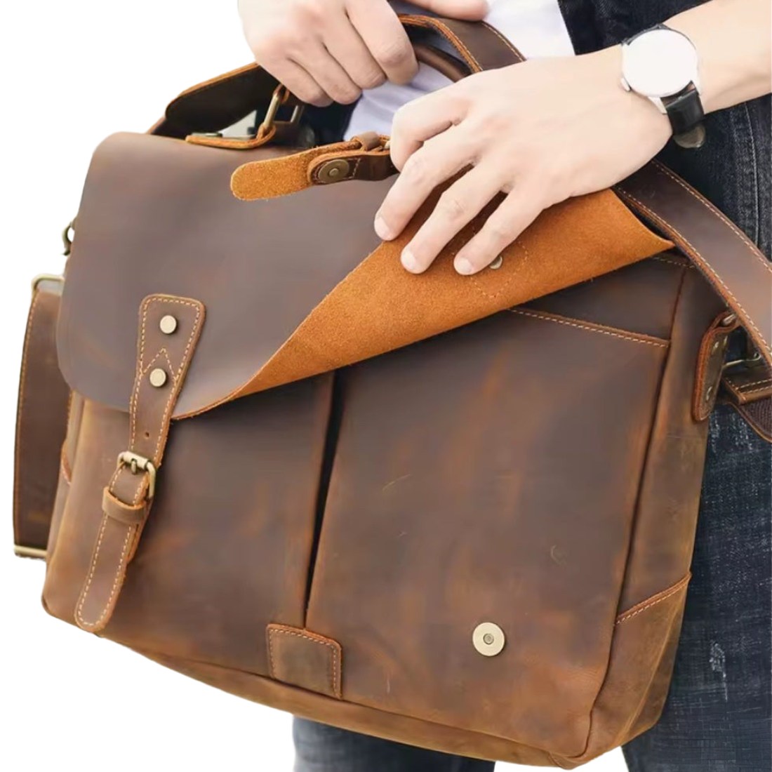 Heritage Legacy Carry messenger bag in brown genuine crazy horse leather with distressed finish shown being opened by hand revealing suede lined interior front pocket and flap with buckle closure showcasing vintage styling and upscale functional design
