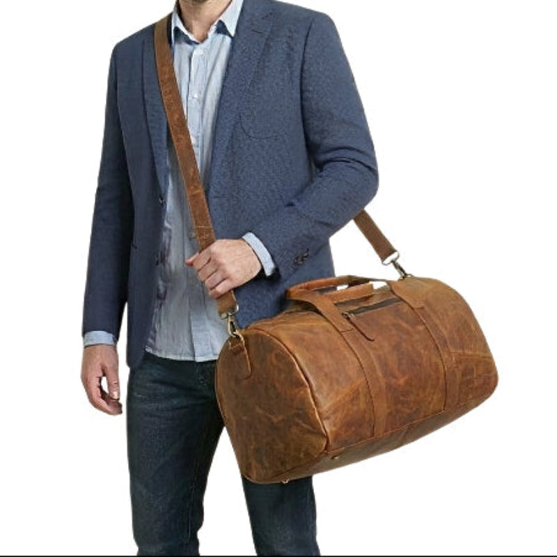 Man carrying horizon leather carry mens brown crossbody leather travel duffel bag with an adjustable removable shoulder strap