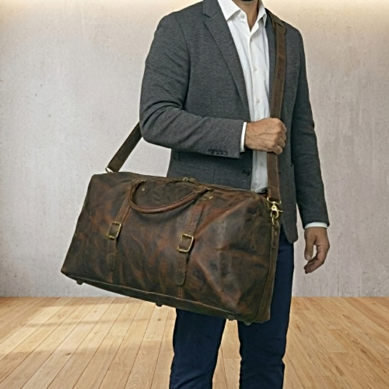 Man holding landmark leather weekender brown leather duffel bag as a leather crossbody travel bag