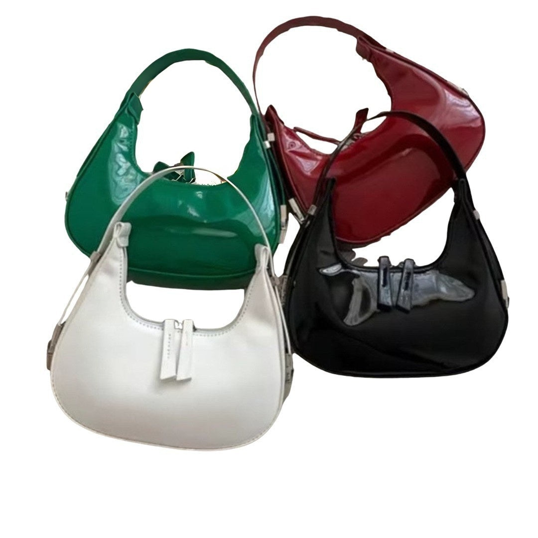 Luna Curve Carry luxury bag in glossy red vegan leather with crescent silhouette single shoulder strap and dual front bow accents silver hardware showcasing bold feminine styling polished premium finish and compact everyday elegance