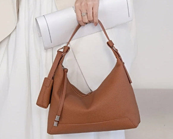 Metro Leather Hobo women's brown leather shoulder bag with textured finish, silver hardware, handheld by model