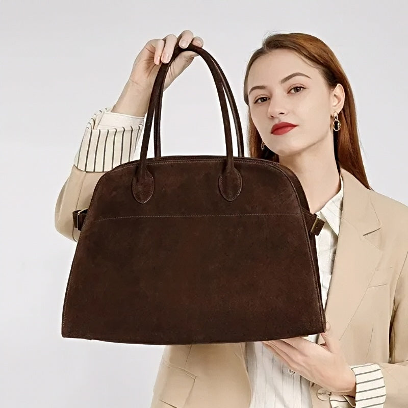 Woman holding modern grace tote a large brown suede handbag