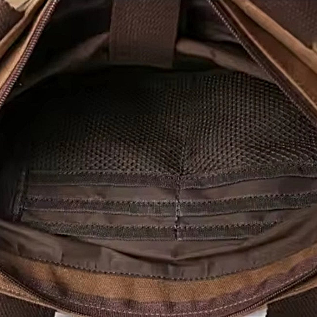 Nomad Utility Carry durable bag in brown canvas shown open to reveal interior mesh pocket and stitched compartments showcasing durable premium construction and rugged organized layout for everyday versatility