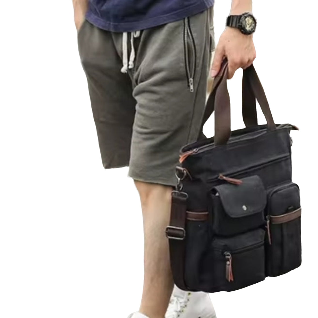 Nomad Utility Carry bag in black durable canvas with brown leather accents shown held by model featuring multiple compartments zippered and flap pockets dual handles and adjustable shoulder strap showcasing durable premium construction and rugged upscale styling for everyday mobility