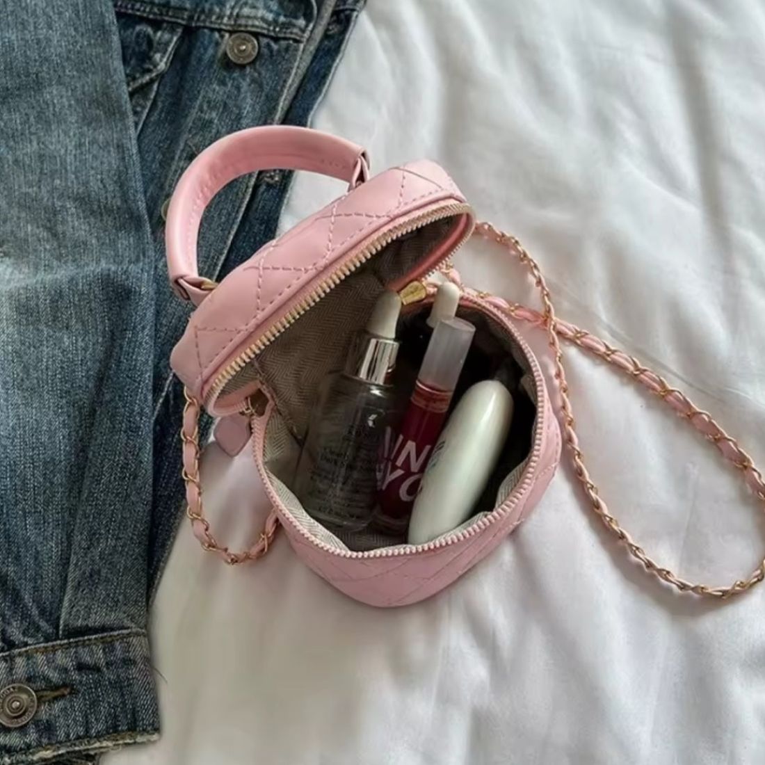 Timeless Petite Luxe elegant pink quilted crossbody bag in luxury vegan leather with upscale gold chain strap open to reveal cosmetics and personal items showcasing elegant lifestyle setting