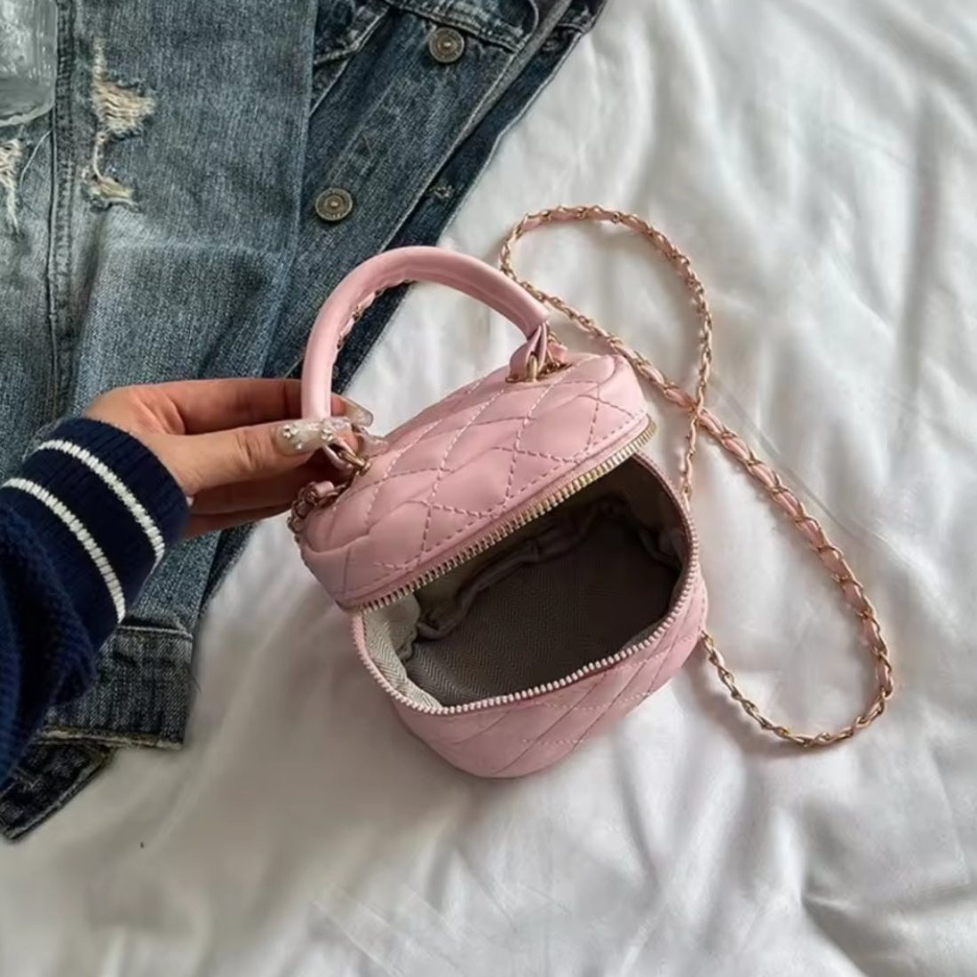 Timeless Petite Luxe in luxury pink quilted vegan leather with elegant gold chain strap structured silhouette held by hand placed showcasing upscale lifestyle setting