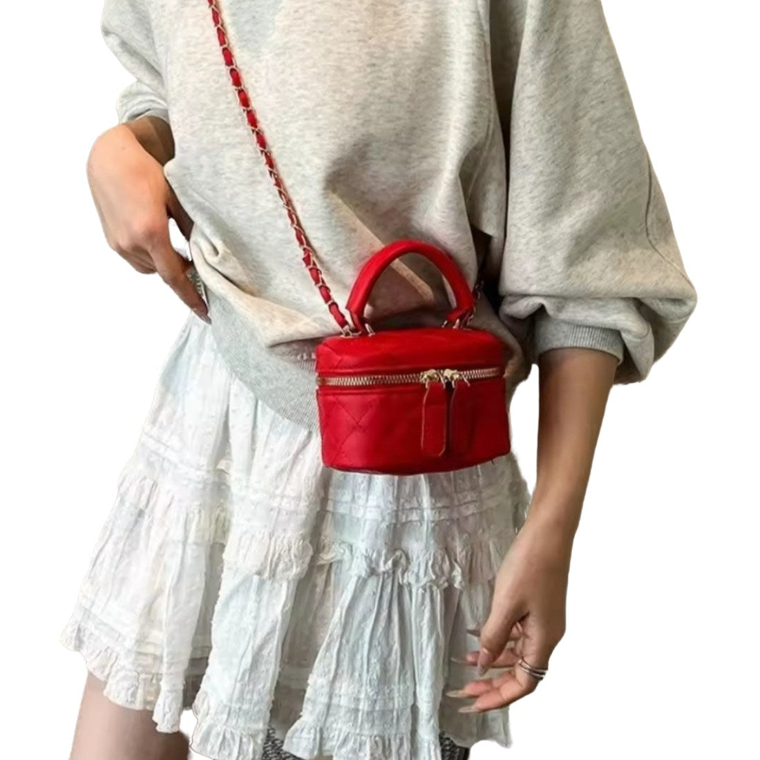 Timeless Petite Luxe crossbody bag in bright red luxury vegan leather with elegant gold zipper and structured top handle worn crossbody over model sleeve top upscale lifestyle setting