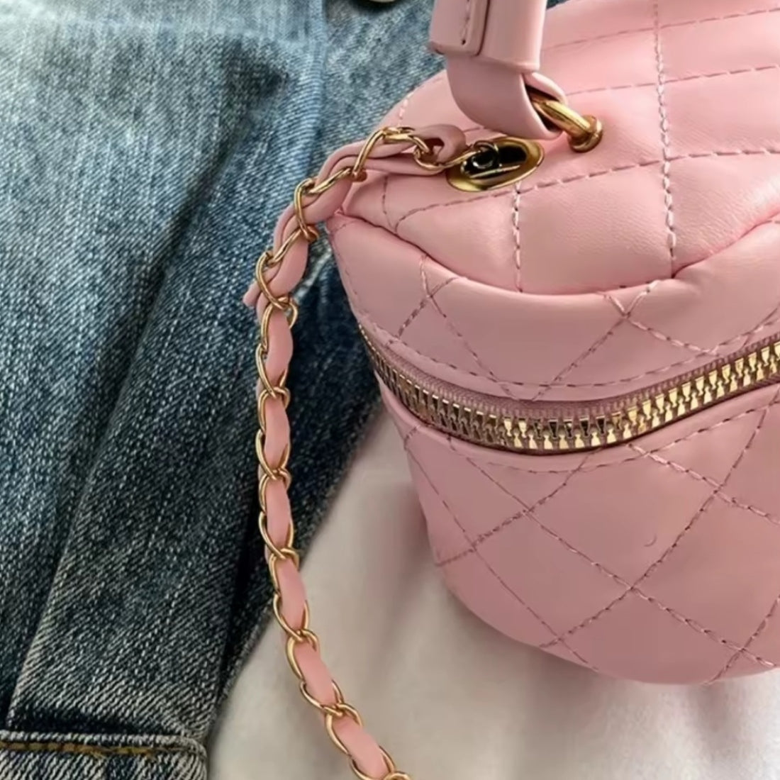 Timeless Petite Luxe crossbody bag in elegant pink quilted vegan leather with upscale gold zipper and elegant braided pink and gold strap showcasing premium craftsmanship and luxury lifestyle setting