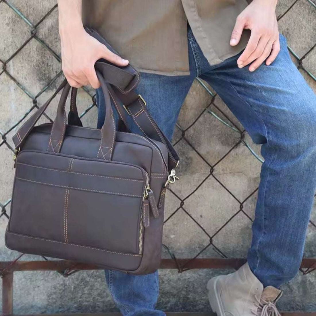 Prestige Leather Briefcase in dark coffee brown full grain genuine leather carried by hand with dual top handles and shoulder strap styled showcasing structured silhouette smooth finish and upscale professional durable presence