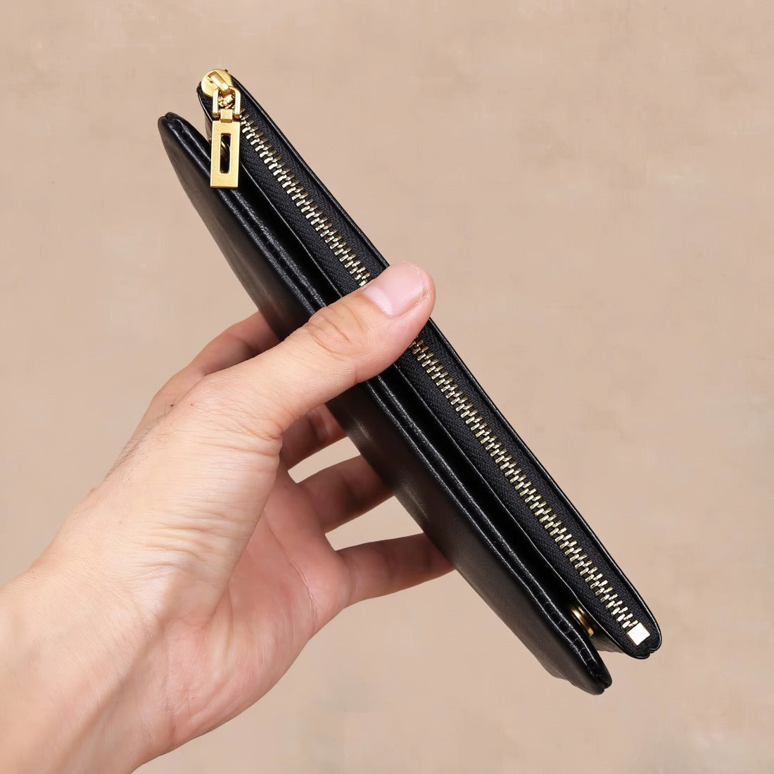 black leather bag wallet in hand for scale