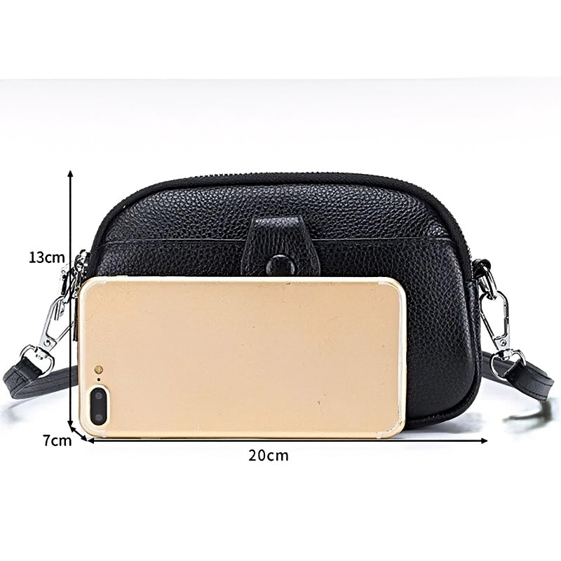 Signature Convertible women’s black leather crossbody bag with detachable strap, shown with a phone and measurements 20cm by 7cm by 13cm.