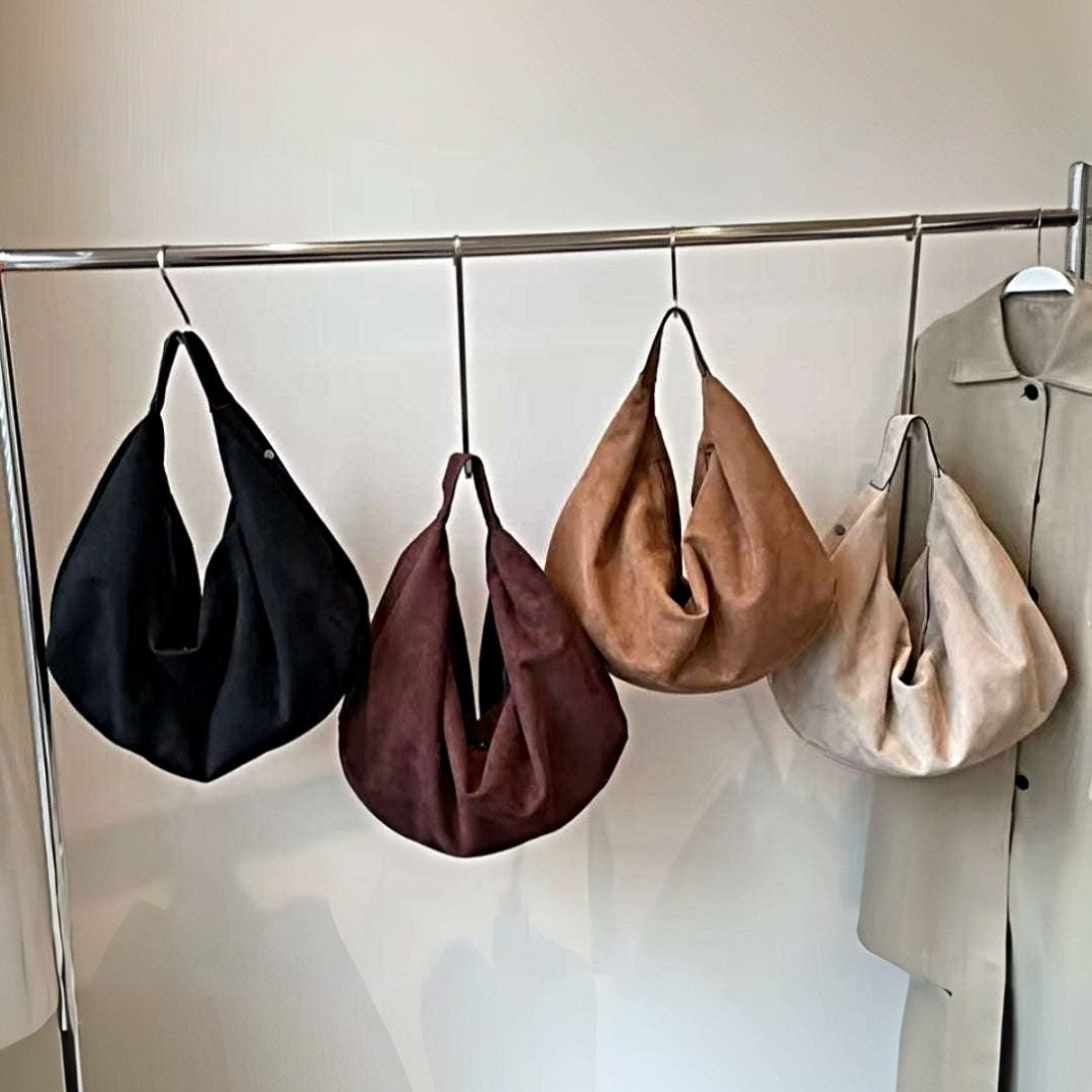 Timeless Suede Hobo luxury bags in black brown chestnut burgundy and beige vegan suede with slouchy silhouette wide shoulder straps and upscale soft texture hanging on clothing rack showcasing velvety finish versatile styling and modern elegant everyday carry