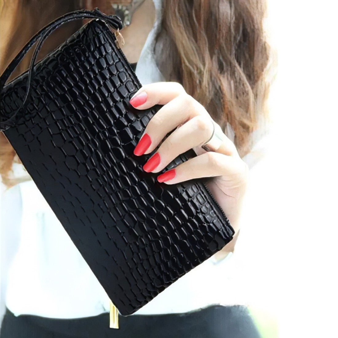 black timeless croc wristlet vegan leather clutch bag held by model for elevated leather bag look