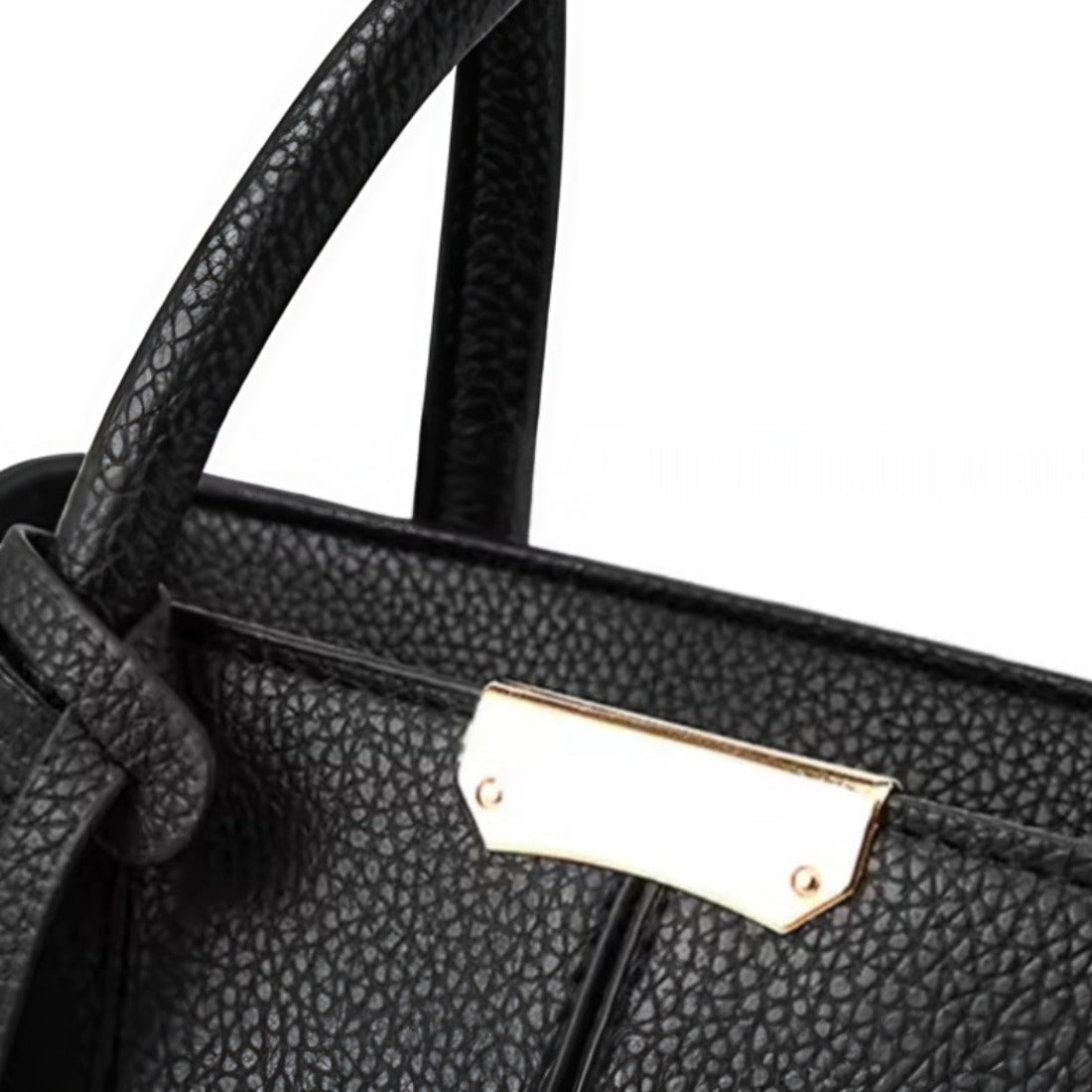 Urban Elegance Satchel in black vegan luxury leather shown in close up view of front handle attachment with pebbled texture and gold tone rectangular brand plate showcasing refined craftsmanship premium detailing and elevated everyday sophistication