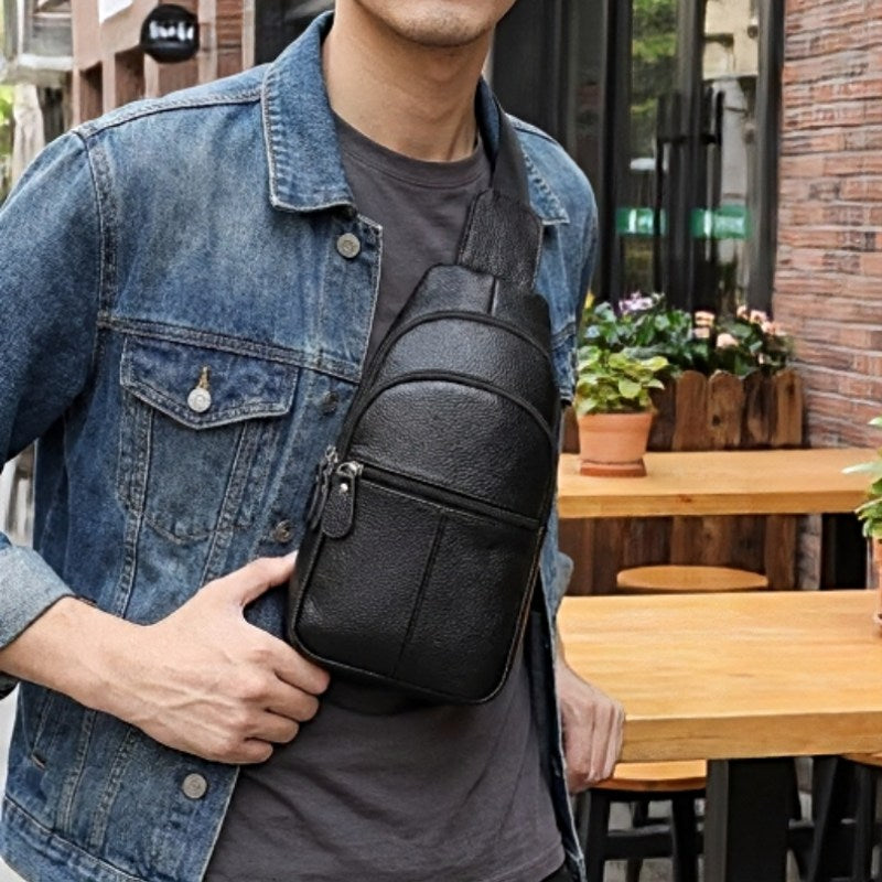 Urban Stealth Sling men’s leather crossbody bag in black with zipper pockets, worn across the chest
