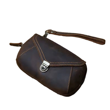 Heritage Utility Carry in dark brown genuine crazy horse leather with distressed luxury oil wax finish compact structured silhouette with triangular flap antique brass clasp and wrist showcasing vintage charm and upscale craftsmanship